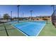 Well maintained outdoor tennis courts, complete with nets, lighting, and lush green surroundings at 4743 S Sungold St, Pahrump, NV 89061