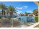 Community view featuring palm trees and a glimpse of residences beyond the blue fence on a clear day at 4960 Harrison Dr # 131, Las Vegas, NV 89120