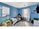 Bright bedroom with large window providing ample natural light, complimented with blue walls at 4977 Vacaville Ave, Las Vegas, NV 89139