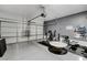 Spacious garage with multiple doors, gray walls, and a home gym setup at 4977 Vacaville Ave, Las Vegas, NV 89139
