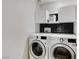 Clean laundry room with front-load washer and dryer and overhead storage at 4977 Vacaville Ave, Las Vegas, NV 89139