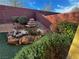 Landscaped backyard featuring a tiered rock garden with a small stone fountain, complemented by green plants and a brick retaining wall at 5361 Candlespice Way, Las Vegas, NV 89135