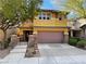 Inviting two-story home featuring a charming stone accent, desert landscaping, and a spacious two-car garage at 5361 Candlespice Way, Las Vegas, NV 89135
