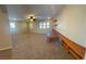 Expansive living room with neutral carpet, shutters on multiple windows, built-in shelving and attached table at 5361 Candlespice Way, Las Vegas, NV 89135