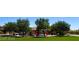 Community playground with multiple play structures and seating surrounded by green lawns and trees at 5361 Candlespice Way, Las Vegas, NV 89135