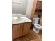 Bathroom showcasing a vanity with a sink, wooden cabinets, and a toilet with storage space above at 5710 E Tropicana Ave # 2003, Las Vegas, NV 89122
