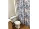 Bathroom features a toilet and a shower with a stylish blue and beige shower curtain at 5710 E Tropicana Ave # 2003, Las Vegas, NV 89122