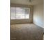 Bright, carpeted bedroom featuring large window with horizontal blinds at 5710 E Tropicana Ave # 2003, Las Vegas, NV 89122
