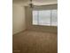 Bright, carpeted bedroom featuring large window with horizontal blinds and ceiling fan at 5710 E Tropicana Ave # 2003, Las Vegas, NV 89122