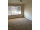 Bright, carpeted bedroom featuring large window with horizontal blinds at 5710 E Tropicana Ave # 2003, Las Vegas, NV 89122
