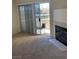 Living room featuring carpet, sliding glass door to patio, and fireplace at 5710 E Tropicana Ave # 2003, Las Vegas, NV 89122