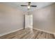 Bedroom with wood-look flooring, ceiling fan, neutral walls, and open door to a connected room at 6121 Edgewood Cir, Las Vegas, NV 89107
