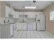 Well-lit kitchen featuring white cabinetry, tile flooring, and stainless steel appliances at 6121 Edgewood Cir, Las Vegas, NV 89107