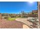 Expansive backyard featuring lush greenery, gravel landscaping, and comfortable lounge chairs at 6472 Chebec St, North Las Vegas, NV 89084