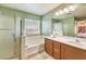 A full bath, featuring double sinks, a soaking tub, and a glass door shower enclosure at 6472 Chebec St, North Las Vegas, NV 89084