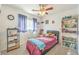 Cozy bedroom with a bed, window, ceiling fan, and a bookshelf; a perfect space for relaxing at 6472 Chebec St, North Las Vegas, NV 89084