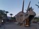 Unique dinosaur sculpture with palm trees behind, offering a memorable and whimsical experience in a recreational park at 6472 Chebec St, North Las Vegas, NV 89084