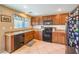 Well-lit kitchen featuring stainless steel appliances, tile flooring, and ample cabinet space at 6472 Chebec St, North Las Vegas, NV 89084