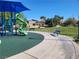 Colorful playground with slides and benches, surrounded by palm trees and a clear blue sky, inviting relaxation and play at 6472 Chebec St, North Las Vegas, NV 89084