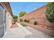 A backyard patio is lined with lovely landscaping and features a brick wall at 7317 Caballo Range Ave, Las Vegas, NV 89179