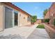 Home exterior featuring a sliding glass door to patio and backyard with mature landscaping at 7317 Caballo Range Ave, Las Vegas, NV 89179