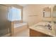 Bathroom featuring double sinks with a luxurious bathtub and a glass-enclosed shower at 7317 Caballo Range Ave, Las Vegas, NV 89179