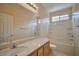 Bathroom featuring a single sink vanity, large mirror, and combined bathtub and shower with tiled surround at 7317 Caballo Range Ave, Las Vegas, NV 89179