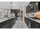 Kitchen with stainless steel appliances, dark cabinets, white backsplash, and wood-look tile flooring at 770 Drewsberry Ave, Las Vegas, NV 89178