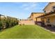 Serene backyard with artificial turf, lounge seating, and a covered patio perfect for outdoor relaxation at 7717 Rosebark Cliffs St, North Las Vegas, NV 89084
