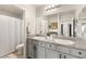 Bathroom boasting dual sinks with granite countertops, ample storage, and a shower/tub combo at 7717 Rosebark Cliffs St, North Las Vegas, NV 89084
