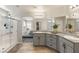 Bathroom featuring double sinks, granite countertops, a glass-enclosed shower, and access to the bedroom at 7717 Rosebark Cliffs St, North Las Vegas, NV 89084