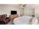 Spacious bedroom with a leather armchair, tv and fan offering a comfortable retreat at 7717 Rosebark Cliffs St, North Las Vegas, NV 89084
