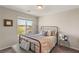 Cozy bedroom with a metal frame bed, patterned bedding, and natural light at 7717 Rosebark Cliffs St, North Las Vegas, NV 89084