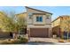 Inviting two-story home featuring a brown two-car garage, stone accents, and manicured landscaping at 7717 Rosebark Cliffs St, North Las Vegas, NV 89084
