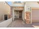 Charming front entrance with stone accents, a covered porch, and a well-lit doorway at 7717 Rosebark Cliffs St, North Las Vegas, NV 89084