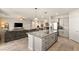 Open-concept living space featuring kitchen island, stainless steel appliances, and large living room area at 7717 Rosebark Cliffs St, North Las Vegas, NV 89084