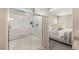 Glass enclosed shower with white subway tile, and peek into bright, spacious bedroom at 7717 Rosebark Cliffs St, North Las Vegas, NV 89084