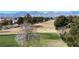 Scenic aerial view of a golf course community with tree-lined streets and mountain views at 7921 Fantail Dr, North Las Vegas, NV 89084