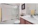 Bathroom featuring a shower-tub combo, sink with wood cabinetry, and neutral-colored walls at 7921 Fantail Dr, North Las Vegas, NV 89084