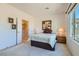 Well-lit bedroom featuring carpet, ensuite bathroom, a comfortable bed, and a scenic view from the window at 7921 Fantail Dr, North Las Vegas, NV 89084