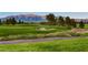 Picturesque golf course with manicured greens, a sand trap, and mountain views showcases luxury community living at 7921 Fantail Dr, North Las Vegas, NV 89084