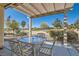 Inviting covered patio with a glass-topped table and seating overlooking lush landscaping at 7921 Fantail Dr, North Las Vegas, NV 89084