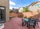 Cozy backyard patio featuring brick pavers, a dining set, and charming garden decor, perfect for outdoor relaxation at 8248 Southern Cross Ave, Las Vegas, NV 89131