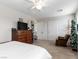 A cozy carpeted bedroom with a ceiling fan, large dresser, closet, and comfortable seating at 8248 Southern Cross Ave, Las Vegas, NV 89131