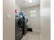 Efficient laundry room with side-by-side washer and dryer and a small window, optimizing space and functionality at 8248 Southern Cross Ave, Las Vegas, NV 89131