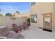 Private backyard patio featuring outdoor furniture, beige stucco walls, and an entrance door at 8432 Squaw Valley Ave, Las Vegas, NV 89128