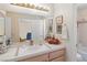 Well-lit bathroom featuring a tile countertop, cabinets, a soaking tub, and an open doorway to the bedroom at 8432 Squaw Valley Ave, Las Vegas, NV 89128