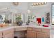 Bright bathroom featuring dual sinks, tile counters, and large mirrors with decorative plants at 8432 Squaw Valley Ave, Las Vegas, NV 89128