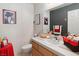 Well-decorated bathroom with a tile countertop, cabinet, and bright lighting at 8432 Squaw Valley Ave, Las Vegas, NV 89128