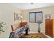 Cozy bedroom featuring warm tones, neutral carpet, and a large window with natural light at 8432 Squaw Valley Ave, Las Vegas, NV 89128